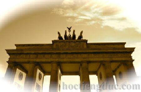 Bức tường Berlin sụp đổ làm nền là Cổng Brandenburg - biểu tượng thống nhất nước Đức